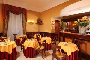 un restaurante con mesas con manteles amarillos y rojos en Hotel Serena srl en Roma