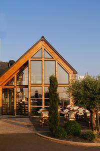 een gebouw met grote ramen met tafels en stoelen bij Auberge de la Baie in Ardevon