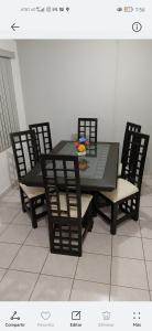 una mesa de comedor y sillas con un tazón de flores. en Hermoso departamento Casa Lirio (Real Solare), en Querétaro