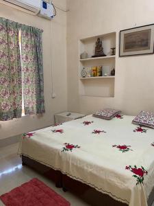 a bedroom with a bed with red flowers on it at Judges Court in Puri