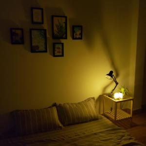 een donkere kamer met een bed en een lamp op een tafel bij One Room in Vung Tau