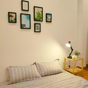 1 dormitorio con 1 cama y cuadros enmarcados en la pared en One Room, en Vung Tau