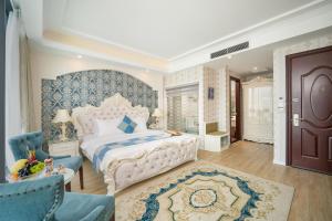 een slaapkamer met een groot bed met een blauw en wit hoofdeinde bij Royal Beach Hotel by THG in Da Nang