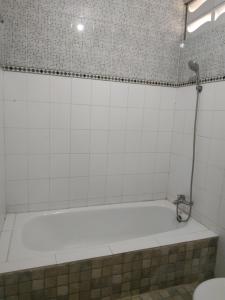 a bath tub in a bathroom with a shower at Hotel Segara in Kintamani