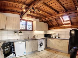 una cocina con electrodomésticos blancos y techos de madera. en Chalet Le Corbier, 6 pièces, 12 personnes - FR-1-267-174, en Le Corbier