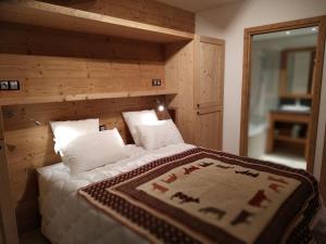 a bedroom with a large bed with a wooden wall at Chalet Saint-Martin-de-Belleville, 4 pièces, 6 personnes - FR-1-344-731 in Saint-Martin-de-Belleville