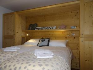 a bedroom with a bed with a wooden wall at Chalet Saint-Martin-de-Belleville, 5 pièces, 8 personnes - FR-1-344-759 in Saint-Martin-de-Belleville