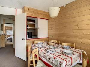 ein Esszimmer mit einem Tisch mit Tellern und Schüsseln darauf in der Unterkunft Appartement spacieux 6 pers · Proche des pistes · Parking inclus - FR-1-344-750 in Les Menuires
