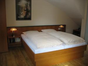 een groot wit bed in een kamer met 2 lampen bij Altes Zollhaus am Klinikum in Lübeck