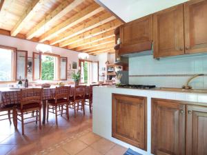 una cocina con armarios de madera, mesa y sillas en Mountain-view holiday home in Cison di Valmarino with garden, en Cison di Valmarino