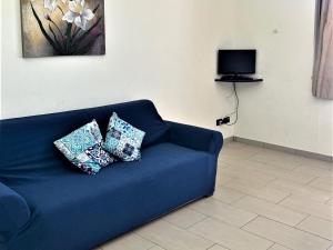 un sofá azul con 2 almohadas en la sala de estar en Modern apartment in Ispica with private terrace, en Ispica