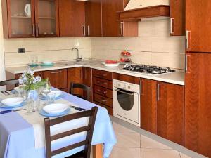 cocina con mesa y fogones horno superior en Modern apartment in Ispica with private terrace, en Ispica