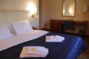 a hotel room with a bed with towels on it at Hotel Posta in Cecina