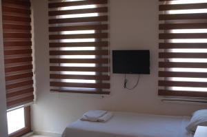 a bedroom with wooden blinds and a bed and a television at Astoria Life Hotel in Marmaris