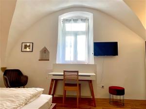 Schlafzimmer mit einem Schreibtisch und einem Fenster in der Unterkunft Appartements im Herzen der Passauer Altstadt in Passau