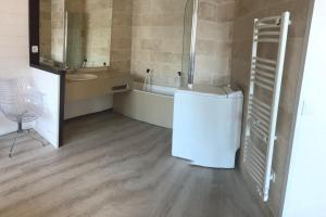 a bathroom with a tub and a sink and a washing machine at Appartement "le chamois" la mongie centre 6 pers Bel appartement standing in La Mongie