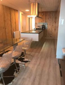 a kitchen with a table and chairs and a counter at Appartement "le chamois" la mongie centre 6 pers Bel appartement standing in La Mongie