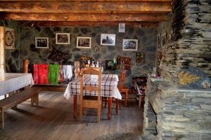 a dining room with a table and a stone wall at Guesthouse Tushetian Tower in Omalo