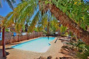 Una piscina con palmeras en un patio. en Kalbarri Reef Villa 3, en Kalbarri