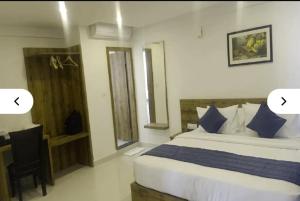 a bedroom with a bed and a chair and a window at Fly Inn in Bangalore