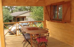 una terraza de madera con mesa y sillas en una casa en Chalet "L'aventure" calme et verdoyant - 6 pers, en Sulniac