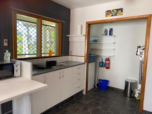 a kitchen with white cabinets and a sink and a window at Central City Art Deco 2 bedroom House in Rotorua