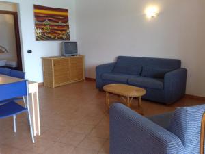 a living room with a couch and a tv at Porto Antigo Two Bed Apartment with Sea View in Santa Maria