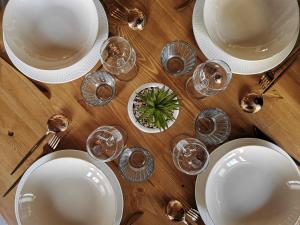 a wooden table topped with white plates and wine glasses at HOME SAVOIE - Le Cygne in Annecy