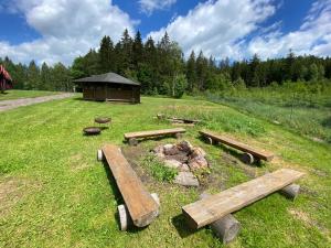 a group of benches in a field with a fire pit at Autokemp Loděnice Zdoňov - Adršpach in Teplice nad Metují