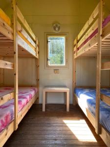 a room with two bunk beds and a table at Autokemp Loděnice Zdoňov - Adršpach in Teplice nad Metují