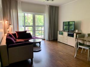 ein Wohnzimmer mit einem Sofa und einem TV in der Unterkunft Sunset Residence - 5 min to the beach! in Narva-Jõesuu