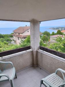 a balcony with two chairs and a view of the ocean at Вила Симеонов in Varna City
