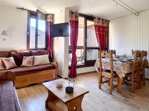 ein Wohnzimmer mit Sofa und Tisch in der Unterkunft Appartement 2 pièces près des pistes avec parking inclus - FR-1-344-797 in Les Menuires