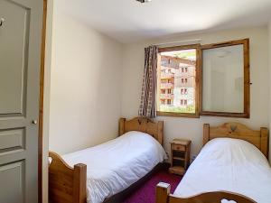 two beds in a small room with a window at Appartement Les Menuires, 3 pièces, 6 personnes - FR-1-344-798 in Levassaix