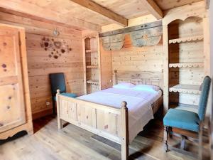 a bedroom in a log cabin with a bed and two chairs at Chalet Saint-Martin-de-Belleville, 5 pièces, 8 personnes - FR-1-344-791 in Saint-Marcel