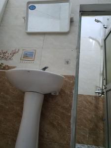 une salle de bain avec un lavabo et un miroir au mur dans l'établissement Nha Xanh Ha Long Homestay, à Hạ Long