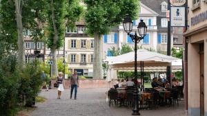 a group of people walking down a street with tables and chairs at MAMA with mobile aircon, including free parking space at 300 meters in Colmar