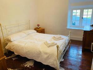 Un dormitorio con una cama blanca con toallas. en Farmhouse Cottage set in beautiful countryside, en Oswestry