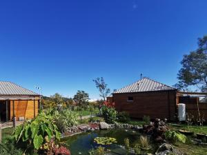 a garden with a pond in front of a building at Tamar'Inn in Le Tampon