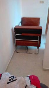 una silla sentada en una habitación al lado de un piso en Топ център Варна, на минути пеш от морето!, en Varna