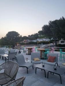 - un ensemble de chaises et de tables sur une terrasse dans l'établissement Camping L'ILE D'OR, à Saint-Raphaël