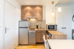 a kitchen with wooden cabinets and a white refrigerator at Chez Jacques par Dodo-a-Cassis in Cassis