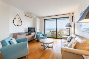 een woonkamer met een bank, stoelen en een televisie bij Chez Jacques par Dodo-a-Cassis in Cassis