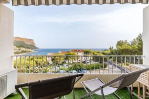 een balkon met twee stoelen en uitzicht op de oceaan bij Chez Jacques par Dodo-a-Cassis in Cassis