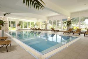 a large swimming pool in a house with chairs at The View - Design Panorama Lodge DAS SCHILLER in Bad Gastein