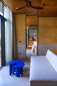 una camera con un letto e due tavoli blu in una stanza di Birdcage 33 Hotel - Adult Only a Yalıkavak