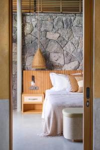 a bedroom with a stone wall and a bed at Birdcage 33 Hotel - Adult Only in Yalıkavak