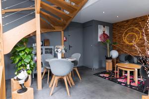 une chambre avec une table, des chaises et un escalier dans l'établissement En Marge, à Aureville