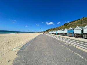 a deserted beach with a row of beach houses at The Alice Apartment - by Coastline Retreats - Stunning Balcony Apartment with Sea Views - Alice in Wonderland Themed Secret Room - Luxury Copper Bath in Master Bedroom in Southbourne