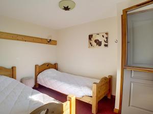 a bedroom with two twin beds and a window at Appartement Les Menuires, 3 pièces, 6 personnes - FR-1-344-849 in Levassaix